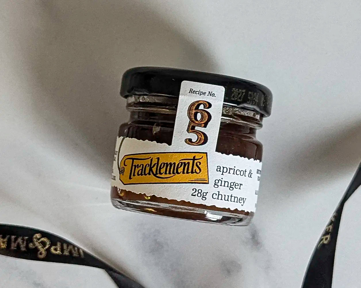 Small jar of Tracklements apricot & ginger chutney on a marble surface