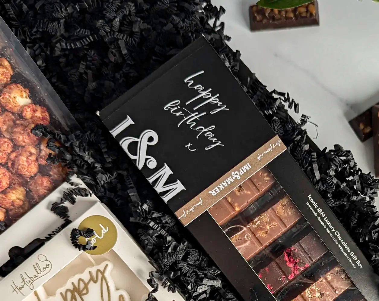 Personalized chocolate gift box with 'Happy Birthday' text on a black textured background