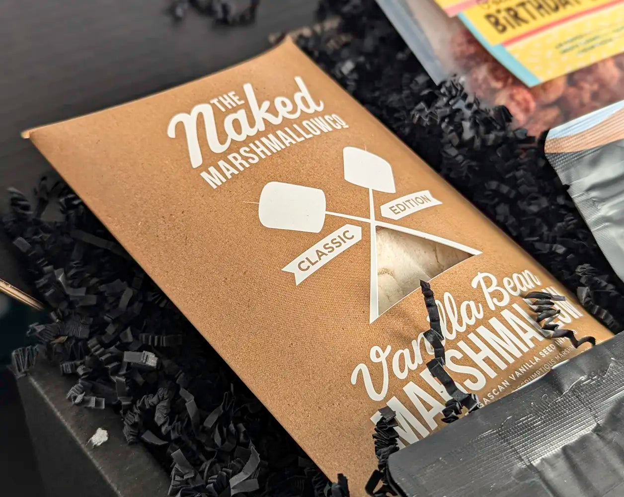 Naked Marshmallows packaging with vanilla bean flavor on a dark background