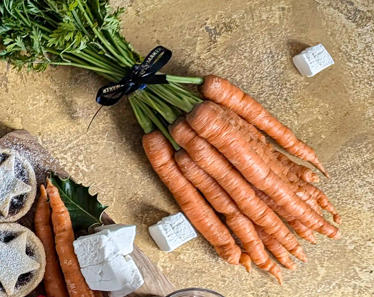 Bunch of carrots on a textured surface with other items