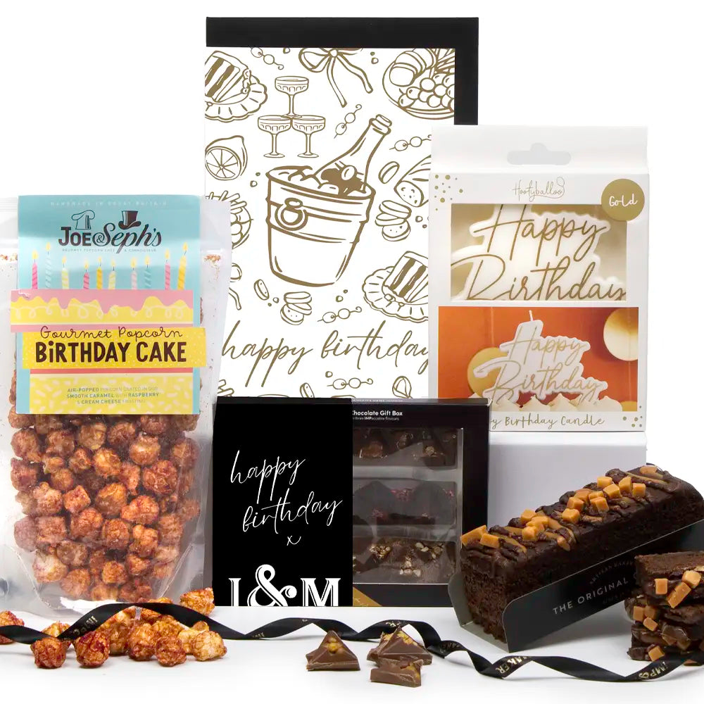 Collection of birthday-themed gifts including chocolate, popcorn, and a card on a white background