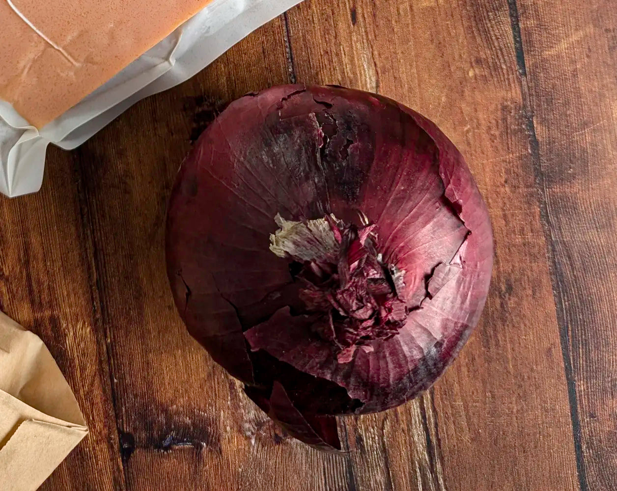 A red onion on a wooden background