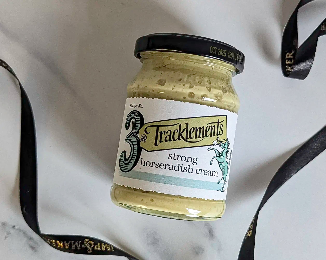 Jar of Tracklements strong horseradish cream on a marble surface