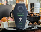 Halloween-themed treat box with ghoulish treats on a decorative plate.