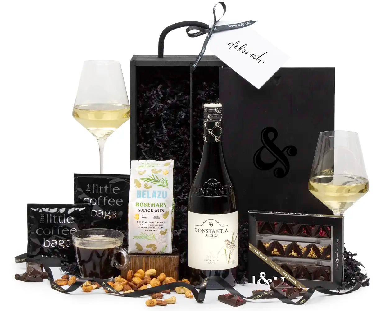 Gourmet gift set with wine, snacks, and coffee on a white background