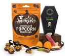 Halloween-themed chocolate popcorn pumpkins with packaging and gummy sweets on a white background