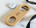 Wooden bottle opener with 'Imp & Maker' branding on a marble surface.
