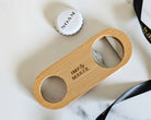 Wooden bottle opener with 'IMP & MAKER' branding on a marble surface.