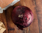 A red onion on a wooden background