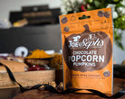 Joe Seph's Chocolate Popcorn Pumpkins packaging on a wooden surface with blurred background