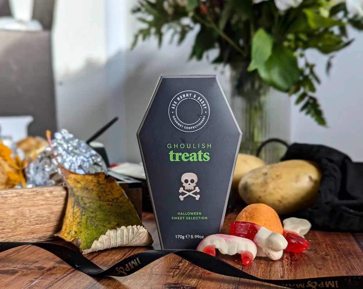Halloween-themed treat package with candy on a wooden surface